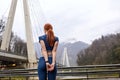 Rear view on redhead female stretching muscles before running at the day time outdoors