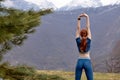 Rear view on redhead fitness woman stretching arms before workout training