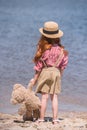 Child with teddy bear at seashore Royalty Free Stock Photo