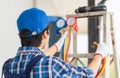 Rear view of repairman fixing air conditioner unit, Technician man installing an air conditioning in a client house, Maintenance Royalty Free Stock Photo