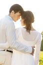 Rear view of romantic couple standing arms around against clear sky Royalty Free Stock Photo