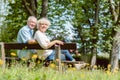 Romantic elderly couple sitting together on a bench in a tranquil day