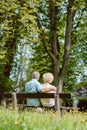 Romantic elderly couple sitting together on a bench in a tranqui