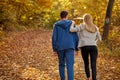 Rear view on romantic young couple enjoying walk in the autumn sunny forest Royalty Free Stock Photo