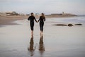 Rear View Of Romantic Young Couple Running On The Beach Together Royalty Free Stock Photo