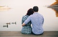 Rear view of a romantic young couple sitting on Royalty Free Stock Photo