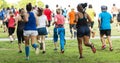 Rear view of runners racing 10K in park on grass