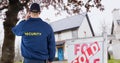 Rear view of security guard standing by sign board with text Royalty Free Stock Photo