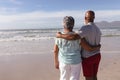 Rear view of senior african american couple hugging each other on the beach Royalty Free Stock Photo
