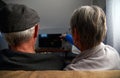 Rear View Of Senior Couple Sitting On Sofa At Home Watching Television Together Royalty Free Stock Photo