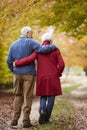 Rear View Of Senior Couple Walking Along Autumn Path Royalty Free Stock Photo