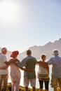 Rear View Of Senior Friends Visiting Tourist Landmark On Group Vacation Standing On Wall Royalty Free Stock Photo