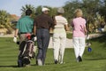 Rear View Of Senior Golfers Walking On Course Royalty Free Stock Photo