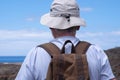 Rear view of senior man with hat enjoying outdoors trekking, looking at horizon over sea Royalty Free Stock Photo