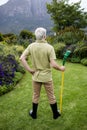 Rear view of senior man standing with garden tool Royalty Free Stock Photo