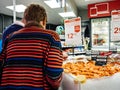 Rear view senior woman buying shrimps supermarket