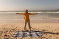 Senior woman standing with arms outstretched on the beach Royalty Free Stock Photo