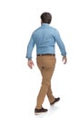 Rear view of a serious casual man walking