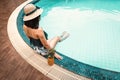 Rear View of Sexy Woman in Swimsuit Relaxing in Swimming Pool, Beautiful Woman Wearing Straw Hat and Relax on The Edge of Poolside Royalty Free Stock Photo