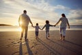 Rear view shot of a carefree family holding hands while walking into the sunset. Mixed race parents and their two kids Royalty Free Stock Photo