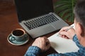 Rear view shot of hands busy business man writing by pen and using laptop at office desk. Royalty Free Stock Photo