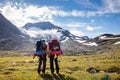 Rear view shot of hiking couple with backpacks, with view to snowy mountains in Norway