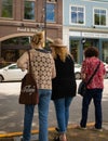 Rear view shot of three women walking together on city street. Female friends out on the street on a summer day Royalty Free Stock Photo
