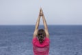 Rear view shot of a young woman practicing yoga at the beach Royalty Free Stock Photo