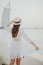 Rear view of a woman wearing casual clothes and straw hat while standing by the sea Royalty Free Stock Photo