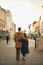 Rear view of a silhouette of a loving couple, hugging while visiting a destination city, walking along the old street of English Royalty Free Stock Photo