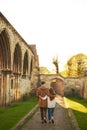 Rear view of a silhouette of a loving couple, hugging while visiting a destination city, walking along the old street of English