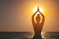 Rear view, silhouette of a woman holding the sun. a girl raising her hands, praying for God's blessings in the light Royalty Free Stock Photo