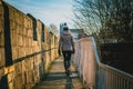 Rear view of a silhouette of a young woman walking along the city walls of York on a sunny day.