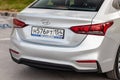 Rear view of silver Hyundai Solaris is parked on the street on a warm day