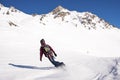 Rear view of skier in sportswear with backpack skiing on snowy mountain Royalty Free Stock Photo