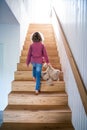 A rear view of small girl walking up wooden stairs indoors at home. Royalty Free Stock Photo