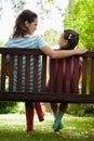 Rear view of smiling woman and girl sitting on bench Royalty Free Stock Photo