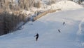 Rear view of snowboarders riding down the snowy slope during a sunny winter day, active lifestyle and sport concept