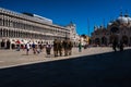 Rear view of some soldiers of the Italian army crossing Saint Mark`s Square in Venice. Beautiful summer day but few tourists