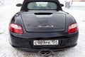 Rear view of the 2006 sports porsche boxster s coupe roadster prepared for sale with a polished shiny black body on snow winter at