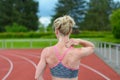 Rear view of sprinter massaging her own neck Royalty Free Stock Photo