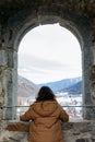Rear view of standing girl watching snowy mountains from the big window Royalty Free Stock Photo