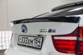 Rear view with tailliamp and spoiler on trunk of luxury very expensive new white BMW X6 M Lumma CLR tuning car stands in the