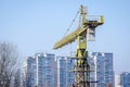 Rear view of tall construction crane in the urban city site with residential buildings in the background Royalty Free Stock Photo