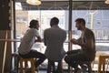 Rear View Of Three Male Friends Meeting In Coffee Shop Royalty Free Stock Photo