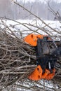 Small stand-on mini skid steer with grapple full of wooden branches