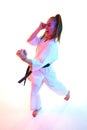 Rear view. Top view portrait of woman professional karate fighter performing kick in action isolated over white Royalty Free Stock Photo