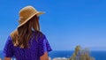 Rear view on tourist woman in summer hat and blue dress on a balcony on a resort hotel on Costa Adeje, Tenerife, Canary Islands Royalty Free Stock Photo