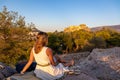 Athens - Rear view of tourist woman looking at Parthenon of the Acropolis of Athens during sunset seen from Pnyx Hill