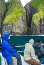 Tourists observing the spectacular Vestmanna cliffs in Faroe Islands Royalty Free Stock Photo